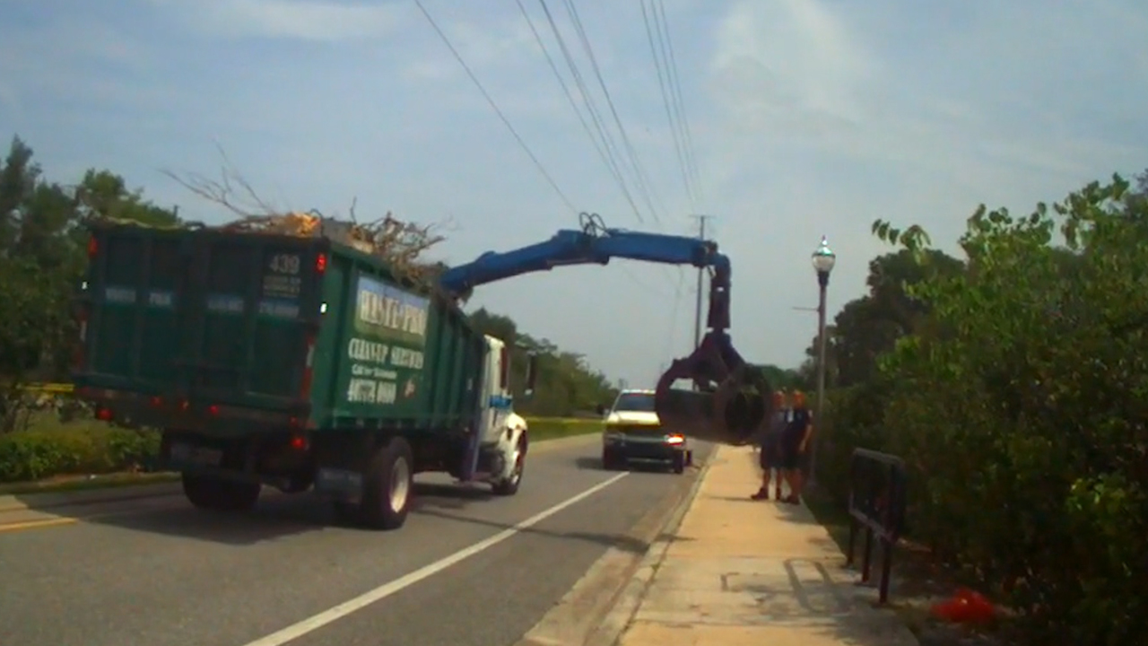 Cyclist dies after being struck by garbage truck equipment